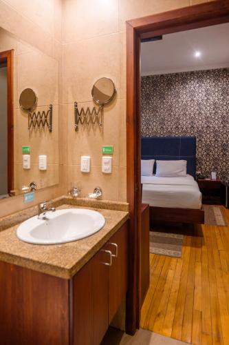 a bathroom with a sink and a bed in a room at Santa Lucia House - Forum in Cuenca