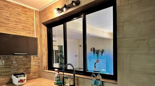 a bathroom with a sink and a large window at LESSENCIEL Villa in Sada