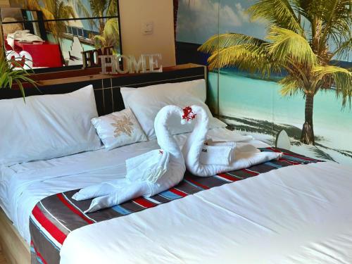 two swans made out of towels on a bed at LESSENCIEL Villa in Sada