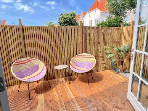 dos sillas sentadas en una terraza con una valla en Thuishaven en Vlissingen