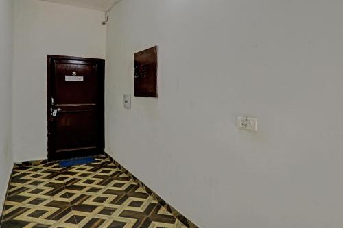 a hallway with a black door and a tiled floor at OYO Dhalio Guest House in Patiāla