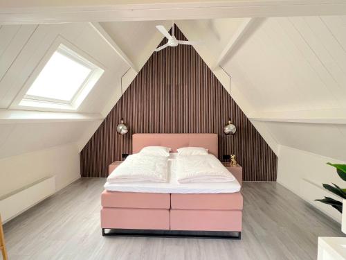 een slaapkamer met een roze bed op zolder bij Thuishaven in Vlissingen
