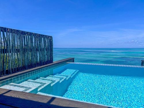 a swimming pool with the ocean in the background at COCOS Hotel Antigua - All Inclusive - Adults Only in Bolans