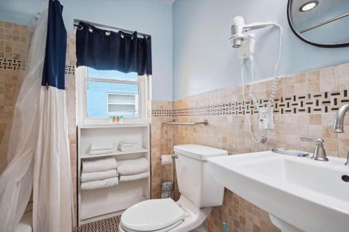 a bathroom with a toilet and a sink and a mirror at Upham Beach Inn - #8 1BR Suite in St. Pete Beach