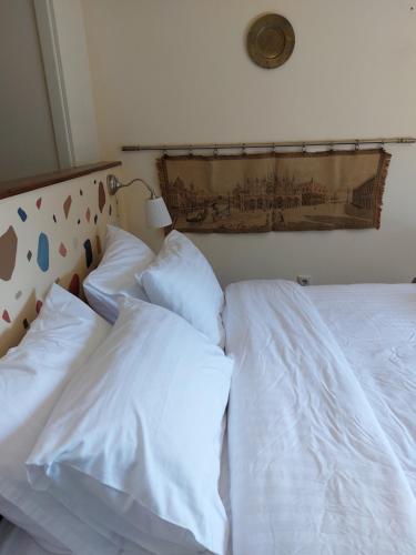 dwie białe poduszki siedzące na łóżku z zagłówkiem w obiekcie Suite Korfes-Κορφές-Σ Αυτόνομη Σουίτα με Τζάκι στην Βίλα Κορφές w mieście Karpenision
