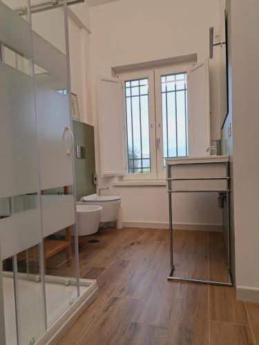 ein Badezimmer mit einem Waschbecken, einem WC und einem Spiegel in der Unterkunft Villa The Green Door - Casa Vacanze vicino a Roma in Fonte Nuova