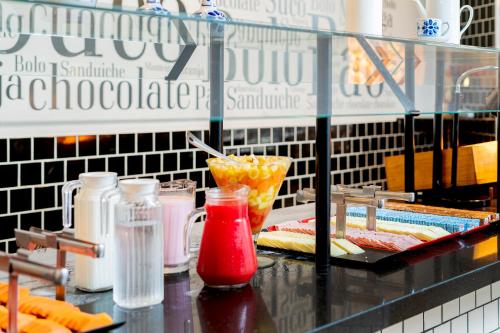a buffet line with food and drinks on a counter at ibis budget SP Centro Sao Joao in Sao Paulo