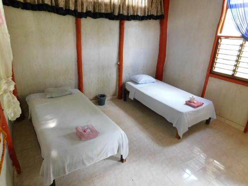 a room with two beds and a window at Centro Social Ecoturistico La Alberca in Jose Maria Morelos