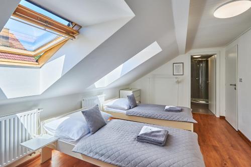 sypialnia na poddaszu z 2 łóżkami i oknem w obiekcie Villa Gap apartments w Czeskim Krumlovie