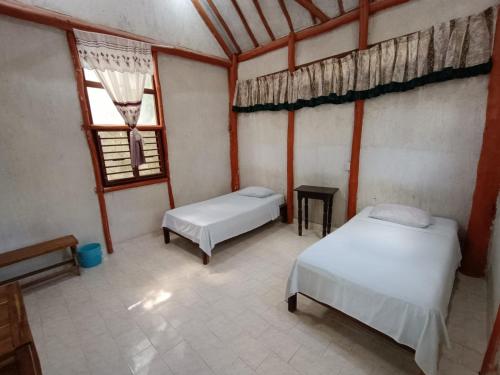 um quarto com duas camas e uma janela em Centro Social Ecoturistico La Alberca em Jose Maria Morelos