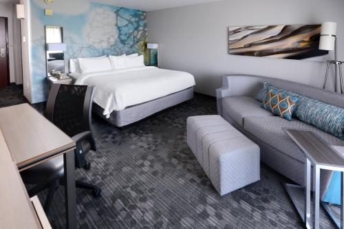 a hotel room with a bed and a couch at Courtyard by Marriott Houston Northwest in Houston