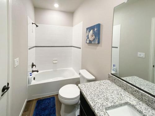 a white bathroom with a tub and a toilet and a sink at Spacious 3 bedroom home in Longmont