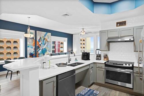 a kitchen with a sink and a stove at Calypso 3-1601 - Corine's Corner in Panama City Beach