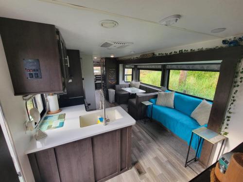 an rv kitchen and living room with a blue couch at The Driftwood Oasis in West Palm Beach