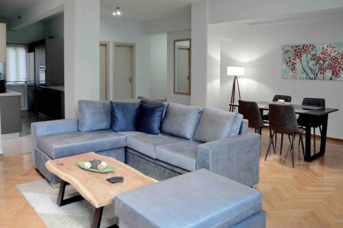 - un salon avec un canapé bleu et une table dans l'établissement Athens heart city centre apartment, à Athènes
