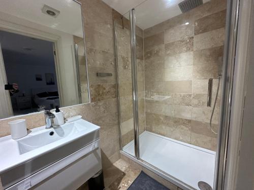 a bathroom with a shower and a sink and a tub at Delightful new ensuite bedroom with stunning shared kitchen & living room -1C The Charteris in London