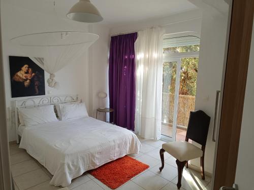 1 dormitorio con cama blanca y ventana en Mare e Monti2, en Agios Konstantinos
