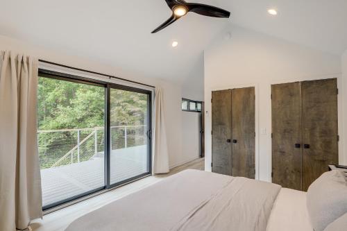 a bedroom with a bed and a large window at Brevard Retreat Fireplace, Deck and Screened Porch! in Brevard