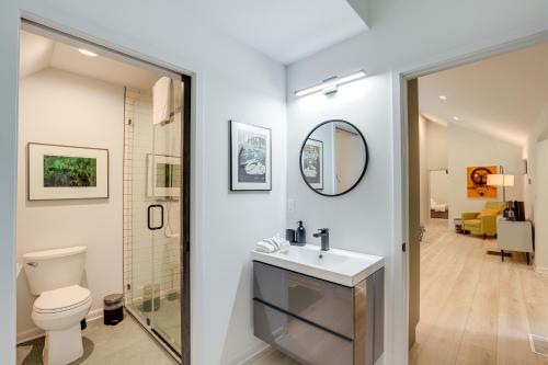 a bathroom with a toilet and a sink and a mirror at Brevard Retreat Fireplace, Deck and Screened Porch! in Brevard