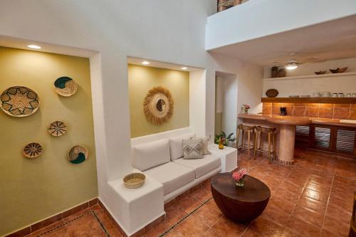 a living room with a white couch and a kitchen at La Villa Luz (sólo adultos) in Zihuatanejo