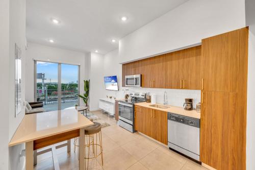 a kitchen with wooden cabinets and a counter top at Modern Unit in Downtown Miami With Free Parking in Miami