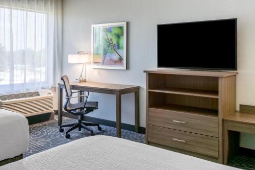 a hotel room with a desk and a television at La Quinta Inn & Suites by Wyndham Valdosta in Valdosta