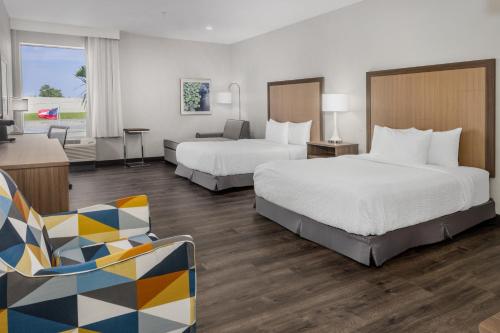 a hotel room with two beds and a couch at La Quinta Inn & Suites by Wyndham Valdosta in Valdosta