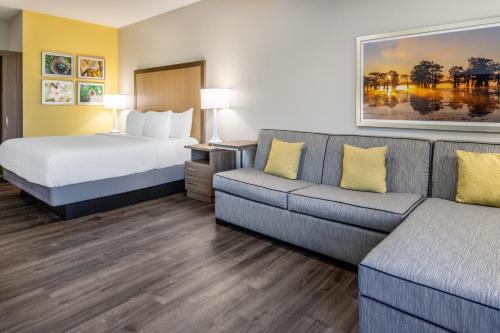 a hotel room with a bed and a couch at La Quinta Inn & Suites by Wyndham Valdosta in Valdosta
