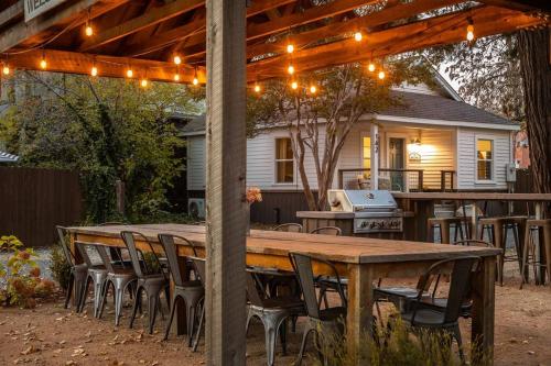 a wooden table and chairs under a pergola with lights at Creektown Cottages The Dogwood in Grass Valley