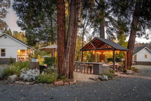 a backyard with a gazebo and tables and trees at Creektown Cottages The Dogwood in Grass Valley