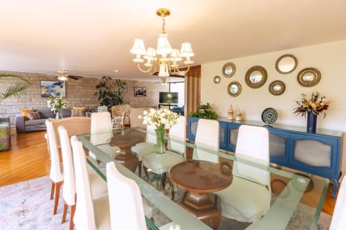 a dining room with a glass table and white chairs at ¡Increíble y amplio departamento! in Mexico City