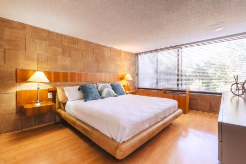 a bedroom with a large bed and a large window at ¡Increíble y amplio departamento! in Mexico City