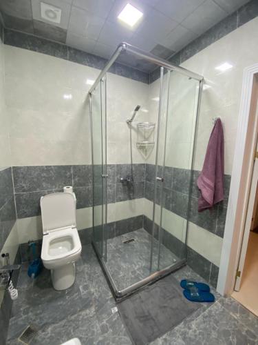 a bathroom with a toilet and a glass shower at Гостевая Квартира in Sumqayyt