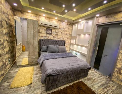 ein Schlafzimmer mit einem Bett in einer Ziegelwand in der Unterkunft فيلا جراند ماجيك الفندقيه in Kairo