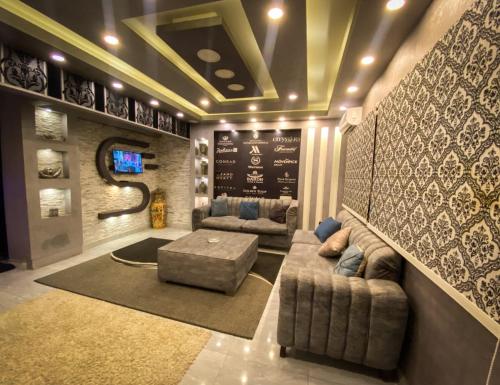 ein Wohnzimmer mit 2 Sofas und einem TV in der Unterkunft فيلا جراند ماجيك الفندقيه in Kairo