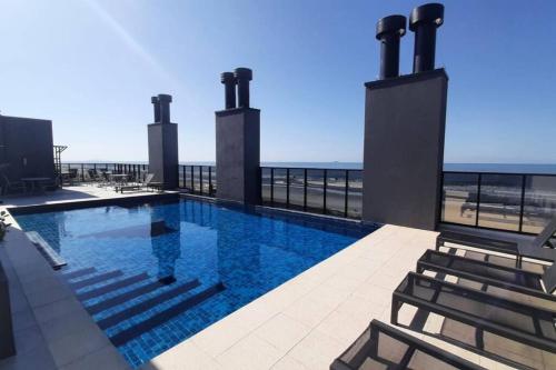 a swimming pool with a view of the ocean at Studio 105 Maravilhoso Frente Mar Piscina Aquecida in Matinhos