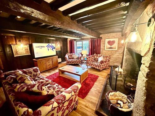 a living room with couches and a flat screen tv at 16th Cent,6 bed house,15 People in Llangwm-isaf