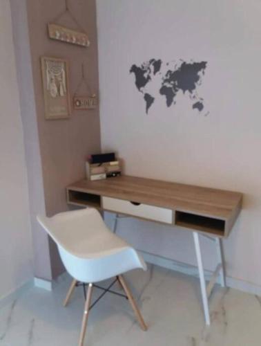 un escritorio con una silla blanca y un mapa mundial en la pared en Lucky apartment Thessaloniki 2 en Tesalónica