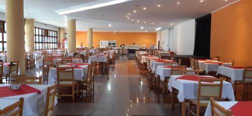 een eetkamer met tafels en witte tafels en stoelen bij Satélite - Campos do Jordão in Campos do Jordão