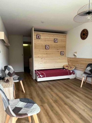 Cette chambre dispose d'un lit avec un mur en bois. dans l'établissement STUDIO Au pied des pistes - Les deux alpes, à Les Deux Alpes