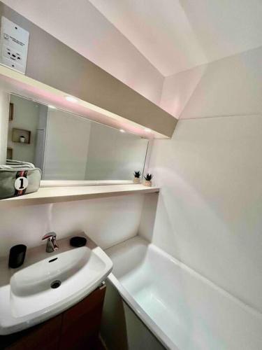 une salle de bain blanche avec un lavabo et un miroir dans l'établissement STUDIO Au pied des pistes - Les deux alpes, à Les Deux Alpes