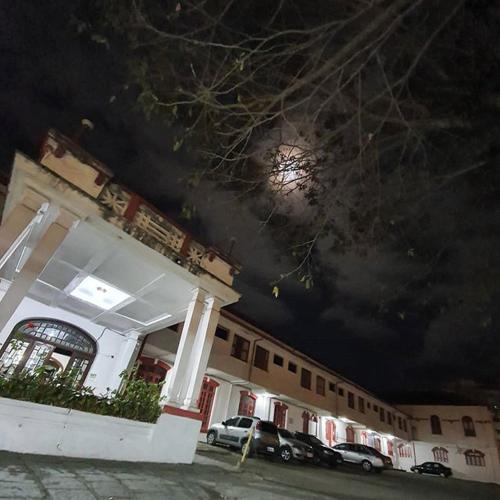 a building with cars parked in front of it at night at Varzea Palace Hotel in Teresópolis