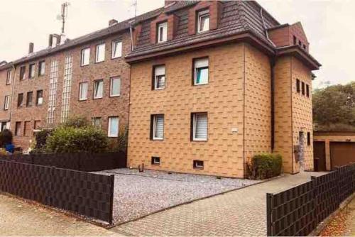 um edifício de tijolos com uma cerca preta em frente em Orient Apartment nähe Autobahn A57 em Krefeld