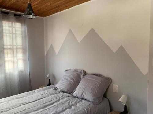 ein Schlafzimmer mit einem Bett, an dessen Wand Berge gemalt sind in der Unterkunft Maison de montagne in Auzat