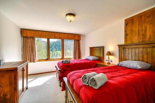 1 Schlafzimmer mit 2 roten Betten und einem Fenster in der Unterkunft Wyoming Retreat on Wood River Hike and Fly Fish! in Meeteetse