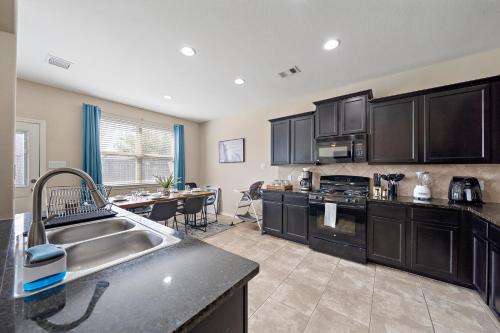 a kitchen with black cabinets and a counter top at Near IAH Houston Home Yard BBQ Games Wi-Fi Pets in Houston