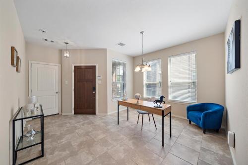 a living room with a desk and a blue chair at Near IAH Houston Home Yard BBQ Games Wi-Fi Pets in Houston