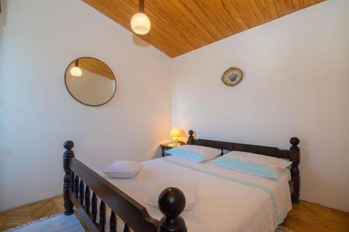 1 dormitorio con 1 cama con espejo en la pared en Apartment Marija, en Pisak