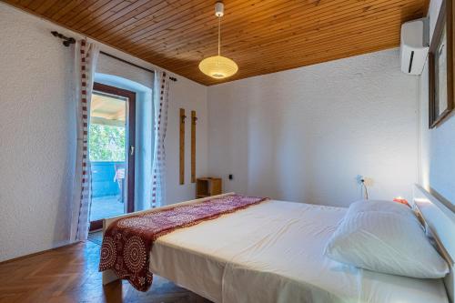ein Schlafzimmer mit einem großen Bett und einem Fenster in der Unterkunft Apartment Lumanera Stivan in Štivan