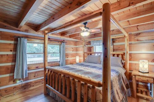 ein Schlafzimmer mit einem Bett in einem Blockhaus in der Unterkunft Cove Life at Tellico Lake Cabin with Hot Tub, Dock in Vonore